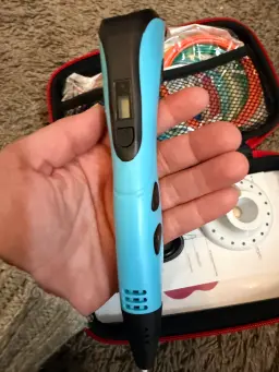 Close up view of the pen held in hand showing the speed controller buttons